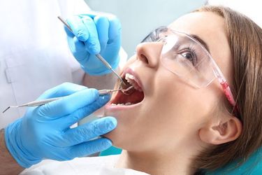 Young woman undergoing a dental exam by a dental professional.